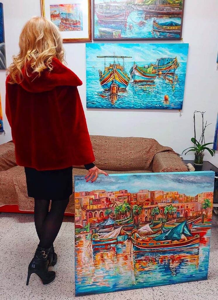 Ilina with boat paintings showcase